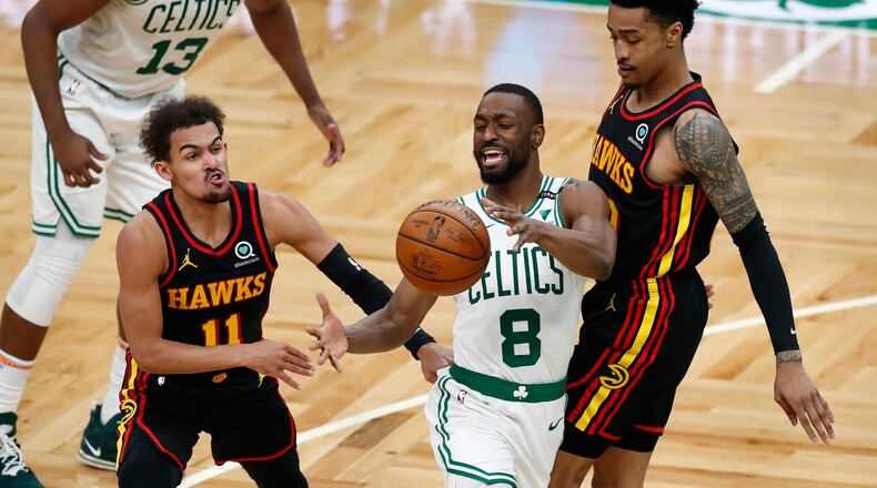 Atlanta Hawks' John Collins, right, fouls Boston Celtics' Kemba Walker (8) as Trae Young (11) defends during the second half of an NBA basketball game Friday, Feb. 19, 2021, in Boston.