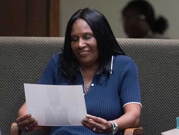 RowVaughn Wells, the mother of Tyre Nichols, smiles as she looks down at a photo of her son that is being submitted as evidence while she takes the stand as a witness during the first day of the criminal trial for the death of Nichols in Memphis, Tenn., on Monday, April 28, 2025. (Chris Day/Commercial Appeal/USA Today Network, via AP, Pool)