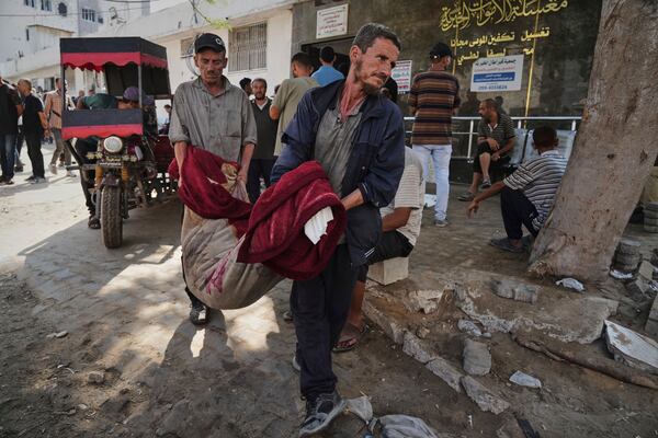 Palestinians carry the body of a person killed in an Israeli army airstrike on Gaza into Shifa Hospital in Gaza City on Tuesday, July 22, 2025. (AP Photo/Jehad Alshrafi)