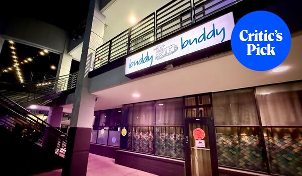 The exterior of a restaurant at a strip mall with a sign that says buddy buddy