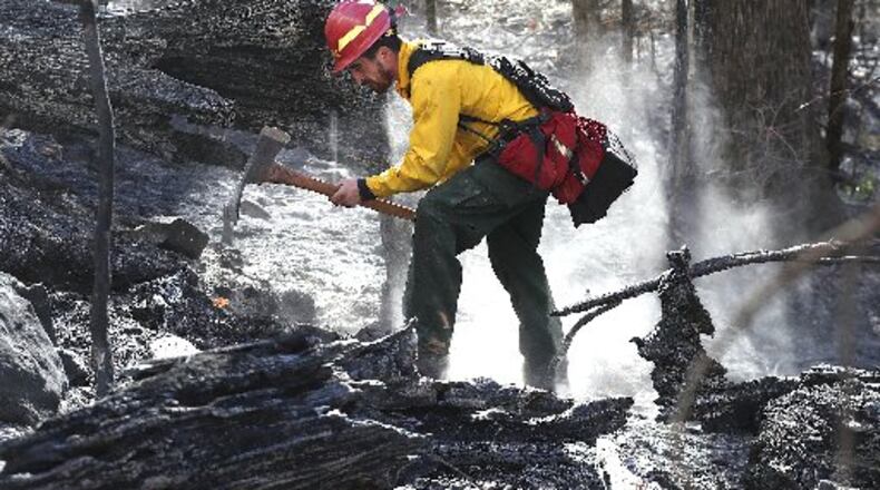 Cody Henderson works to fight the Rock Mountain fire in Rabun County. CURTIS COMPTON / CCOMPTON@AJC.COM