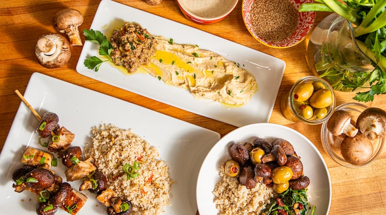 Three versatile ingredients come together in nearly unlimited combinations, including (clockwise, from left) a dinner of Grilled Sesame Chicken skewers with Bulgur Pilaf; a midday treat featuring Olive & Mushroom Tapenade and White Bean Hummus; and a savory breakfast bowl made with Tahini Bulgur Wheat, Roasted Mushrooms & Spanish Olives, and Sauteed Spinach & Bacon. (Aaliyah Man for The Atlanta Journal-Constitution / food styling by Jennifer Hill Booker)