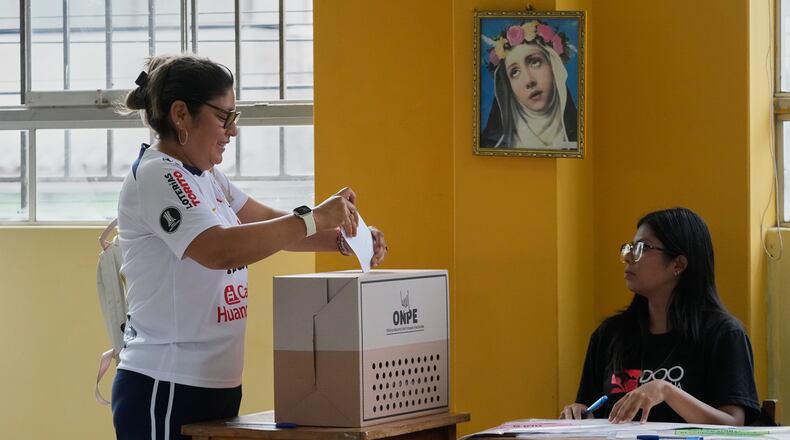 A woman votes as polling resumes at a station affected by delays and logistical problems during general elections in Lima, Peru, Monday, April 13, 2026. (AP Photo/Martin Mejia)
