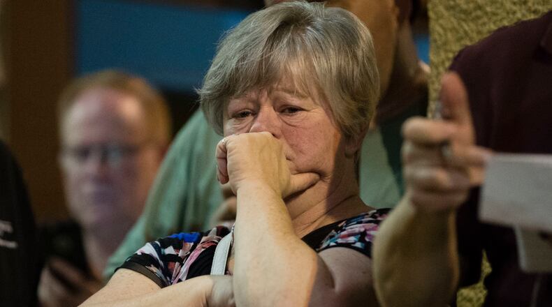 A woman listens to Matthew Weintraub, District Attorney for Bucks County, Pa., speak during a news conference in New Hope, Pa., Thursday, July 13, 2017. Authorities said they've found human remains in their search for four missing young Pennsylvania men and they can now identify one victim. (AP Photo/Matt Rourke)
