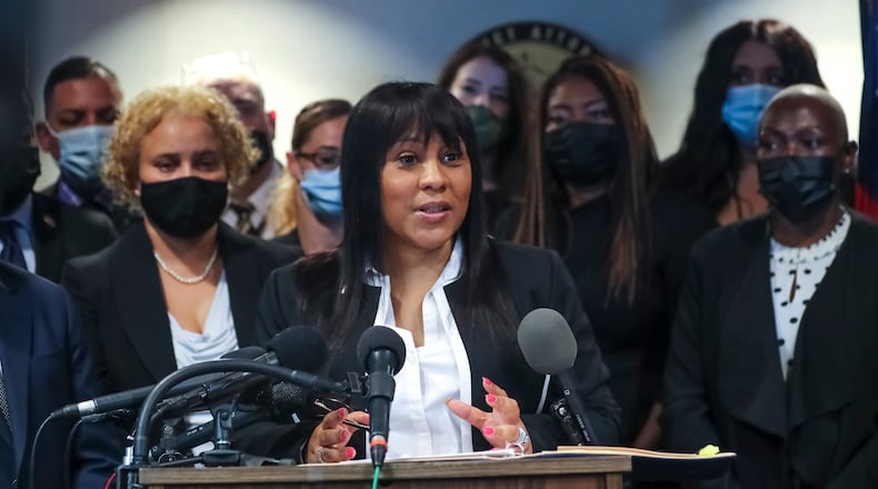 Fulton County District Attorney Fani Willis, center, speaks to the press on Sept. 29, 2021 surrounded by a team of more than three dozen prosecutors and investigators at her office in downtown Atlanta. (John Spink / John.Spink@ajc.com)