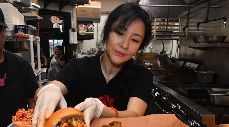 Jiyeon Lee puts the final touches on a sampler platter from Heirloom Market BBQ. (CHRIS HUNT FOR THE ATLANTA JOURNAL-CONSTITUTION)