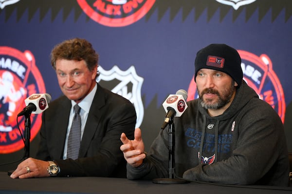 Former NHL player Wayne Gretzky, left, with Washington Capitals Alex Ovechkin, right, during a press conference after an NHL hockey game in which Ovechkin tied Gretzky's NHL career goals record of 894th goals, Friday, April 4, 2025, in Washington. (AP Photo/Nick Wass)