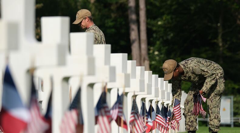 Members of the U.S. Navy help to plant U.S. and French flags at the graves of U.S. soldiers at Normandy American Cemetery on June 05, 2019 near Colleville-Sur-Mer, France. (Photo by Sean Gallup/Getty Images)
