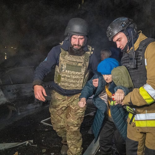 Rescuers evacuate an elderly woman after a residential building was hit following Russia's missile attack in Kharkiv, Ukraine Wednesday, Nov. 19, 2025. (AP Photo/Andrii Marienko)