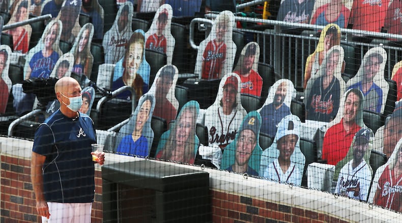 Braves manager Brian Snitker takes in the strange scene of 1,500 cardboard cutouts of fans in the otherwise empty seats at Truist Park prior to a 2020 game. (Curtis Compton/ccompton@ajc.com)