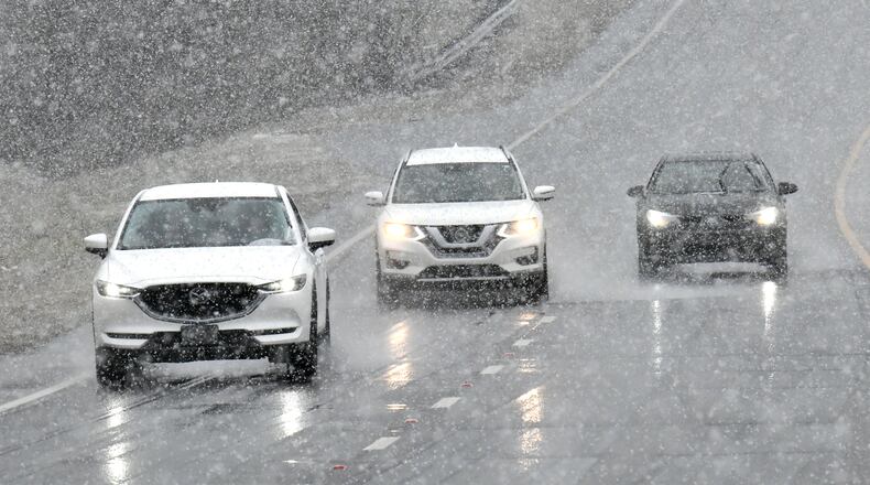 January 16, 2022 Lawrenceville - Drivers navigate Scenic Highway in Lawrenceville as snow falls on Sunday, January 16, 2022. Snowfall continues to move south of I-285 and south Fulton and Coweta counties could see up to 2 inches of snow by Sunday evening. Major impacts near Lake Lanier and into the North Georgia mountains are being felt and certain spots could see up to 10 inches of snow. As of around noon, snow is moving through Troup and Coweta counties, as Fayette and Clayton counties still patiently wait for some flurries amidst the rain and some wintry mix. (Hyosub Shin / Hyosub.Shin@ajc.com)