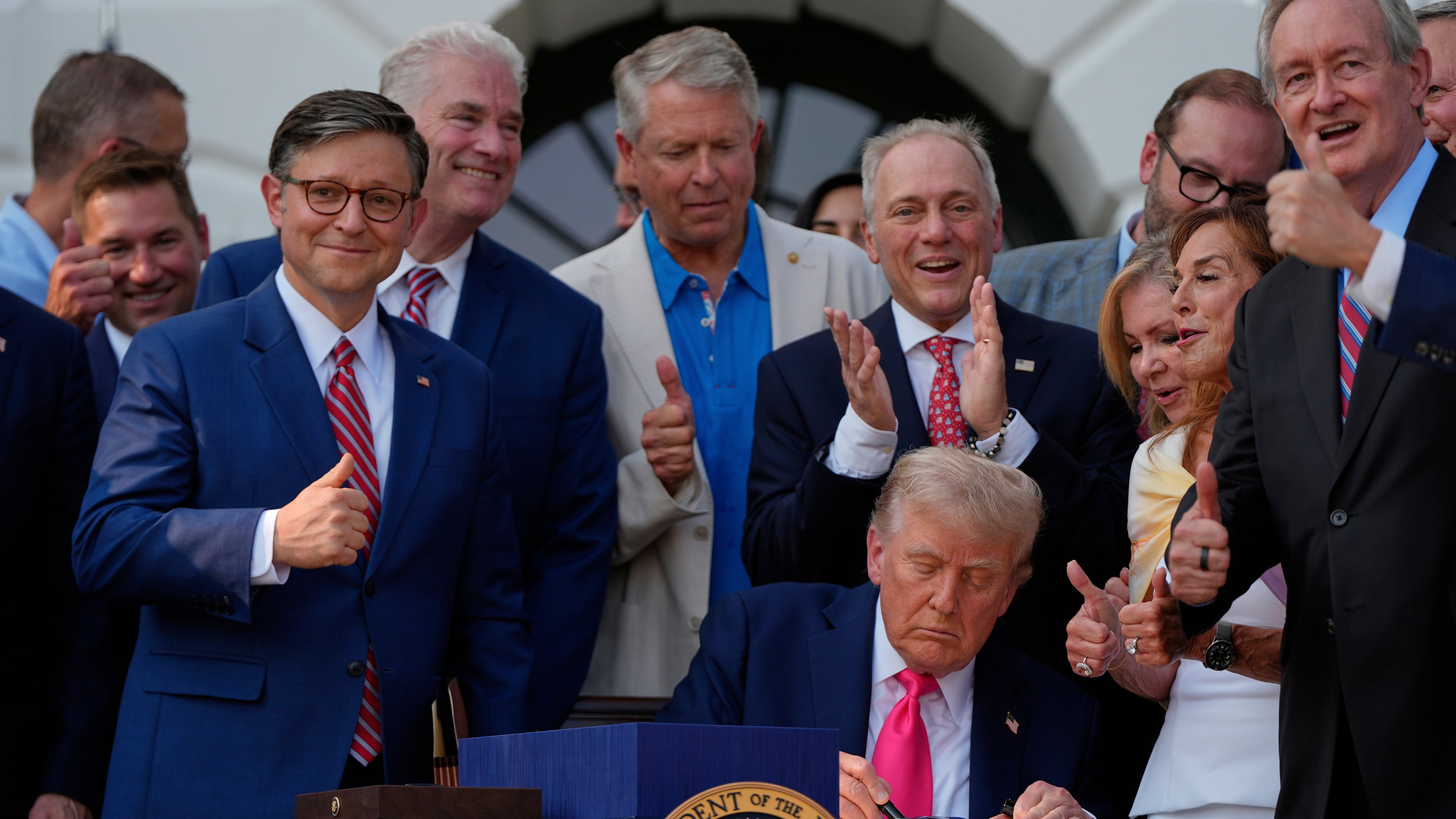 FILE - President Donald Trump signs his signature bill of tax breaks and spending cuts at the White House, July 4, 2025, in Washington, surrounded by members of Congress. (AP Photo/Julia Demaree Nikhinson, File)