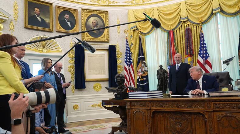 President Donald Trump answers questions from reporters after signing an executive order in the Oval Office of the White House Tuesday, March 31, 2026, in Washington, as Commerce Secretary Howard Lutnick listens. (AP Photo/Alex Brandon)