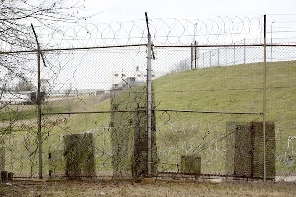 February 21, 2017, Atlanta - Patches of metal are bolted to the fence along the United States Penitentiary in Atlanta to cover holes. Minimum security inmates have used the holes in the fence to smuggle contraband back into the camps for years. (DAVID BARNES / SPECIAL)