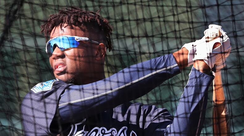 Braves top prospect Ronald Acuna takes some in the batting cage. He arrived early to spring training. (Curtis Compton/ccompton@ajc.com)