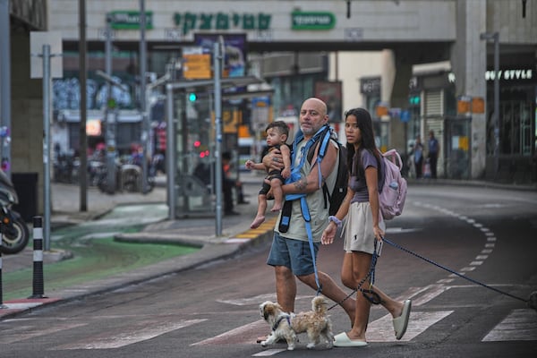 People leave an underground parking garage where they took shelter after an air raid alarm of Iranian missile attacks went off, in Tel Aviv, Israel, Tuesday, June 24, 2025. (AP Photo/Ohad Zwigenberg)