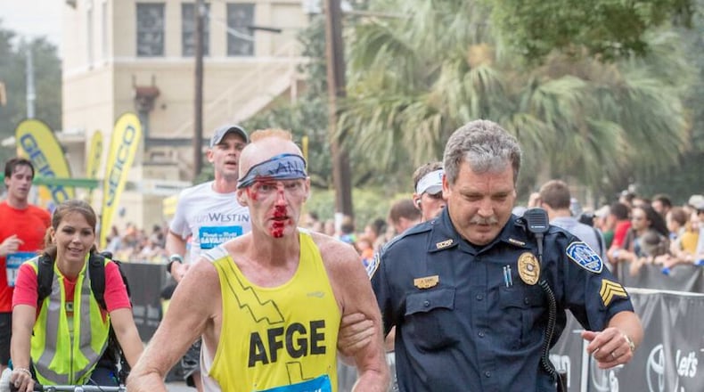 Sgt. John Cain helps injured runner Robert McCoy finish the Rock N' Roll Marathon.