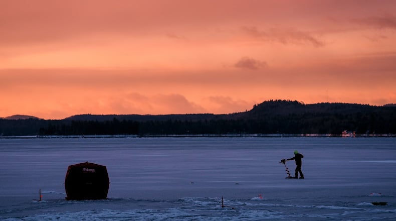 An ice fisherman starts his auger before drilling a hole in the ice on Long Lake following yesterday's freezing rainstorm, Tuesday, Dec. 30, 2025, in Harrison, Maine. (AP Photo/Robert F. Bukaty)