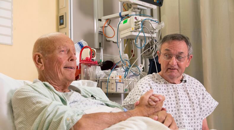 In this Nov. 5, 2015 photo, Henry "Bill" Warner, left, and John Middaugh clasp hands prior to their surgeries at NewYork-Presbyterian/Weill Cornell Medical Center in New York. Serving together in Vietnam, Warner and Middaugh forged an Army-brothers bond they knew was profound and lasting. Nearly a half a century away from the war zone where they'd counted on each other, Middaugh put himself on the line for Warner this month in a new way, by giving one of his kidneys. (AP Photo/Mark Lennihan)