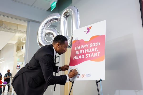 Atlanta Mayor Andre Dickens signs a poster celebrating the 60th birthday of Head Start, a federal early childhood education program, at the Arthur M. Blank Early Learning Center on Monday.