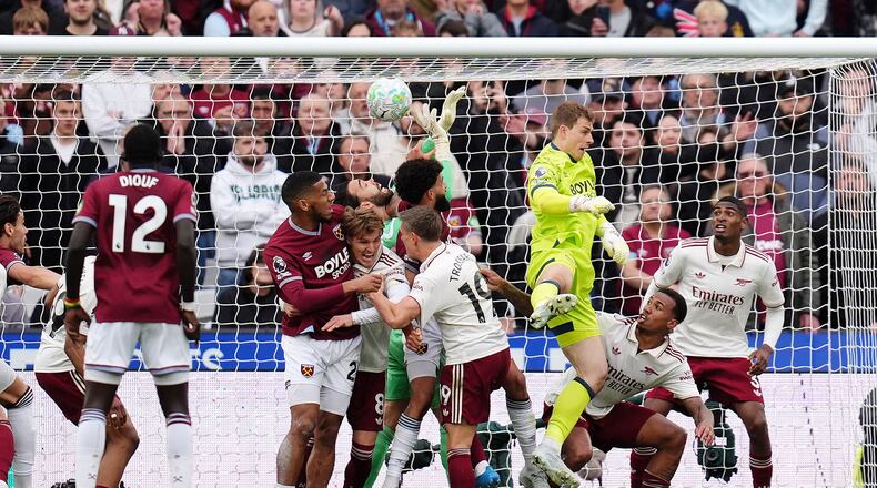 Arsenal goalkeeper David Raya, center, is fouled by West Ham United's Pablo Felipe in the build up to Callum Wilson disallowed goal during the English Premier League match in London, Sunday May 10, 2026. (John Walton/PA via AP)