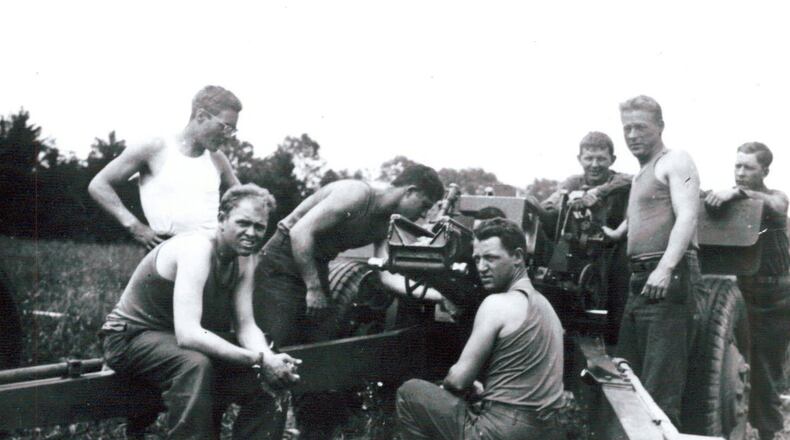 Hilbert Margol and his Howitzer (105 mm) crew during World War II. He said they had just cleaned the gun and he was leaning over, checking the weapon’s mechanism. Photo from Hilbert Margol