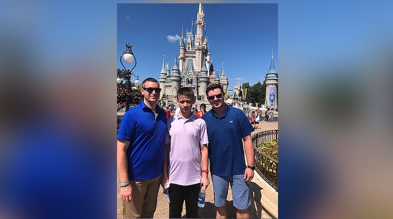 Kevin Herrick and Zach Greene-Herrick pose with their son Richard in front of Cinderella Castle at Walt Disney World in fall 2019. Photo courtesy of Zach Greene-Herrick.