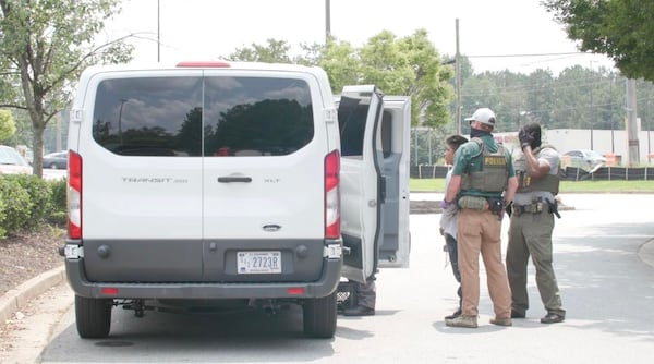 Federal agents arrest day laborers and load them into a white van outside of a Home Depot in Riverdale on June 2.