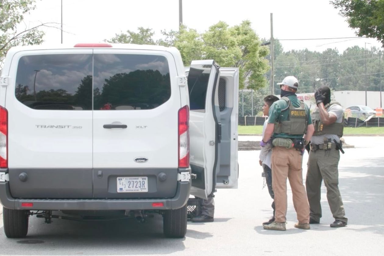 Federal agents arrest day laborers and load them into a white van outside of a Home Depot in Riverdale on June 2.