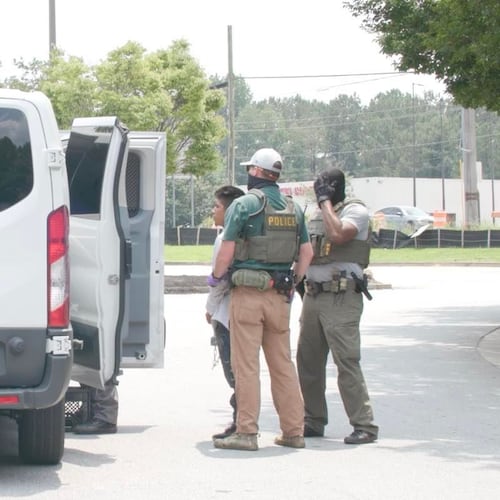 Federal agents arrest day laborers and load them into a white van outside of a Home Depot in Riverdale, Georgia, on June 2.