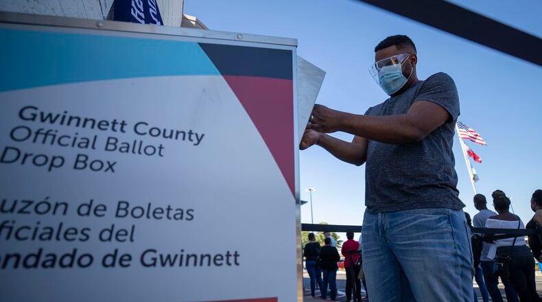A voter deposits his absentee ballot into a drop box in December 2020 in Gwinnett County for the U.S. Senate runoffs. True the Vote, a Texas-based conservative election organization, has alleged that several unnamed organizations paid unnamed individuals $10 per absentee ballot delivered to drop boxes across metro Atlanta during the 2020 presidential election. The organization, however, has refused to provide details and documents to the State Election Board supporting its allegations. Alyssa Pointer / AJC