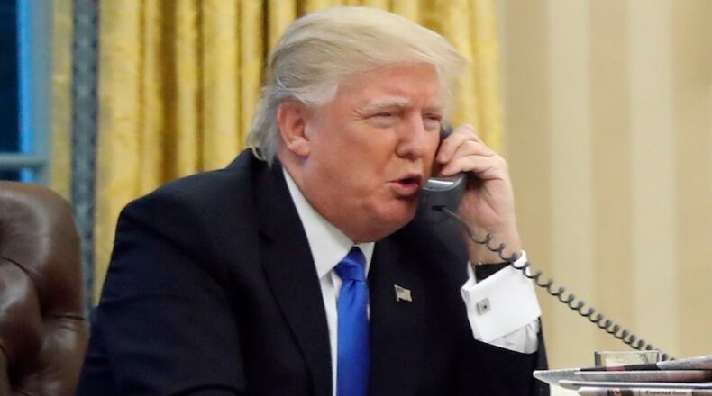 U.S. President Donald Trump speaks on the phone with Prime Minister of Australia Malcolm Turnbull in the Oval Office of the White House, Saturday, Jan. 28, 2017 in Washington. (AP Photo/Alex Brandon)