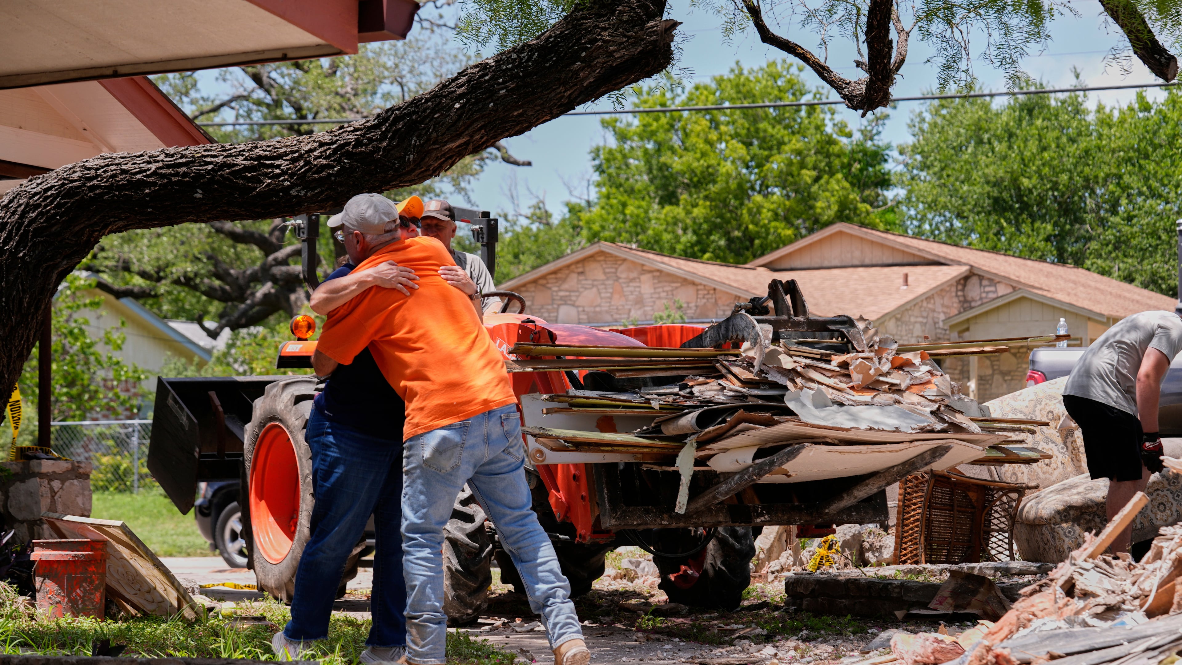 FILE - Homeowner Daniel Olivas hugs Lorrie McMillan, a chaplain with Texans on Mission Disaster Relief, as he clears debris from his home, which was heavily damaged from flash floods along the Guadalupe River in Kerrville, Texas, July 10, 2025. (AP Photo/Gerald Herbert, File)