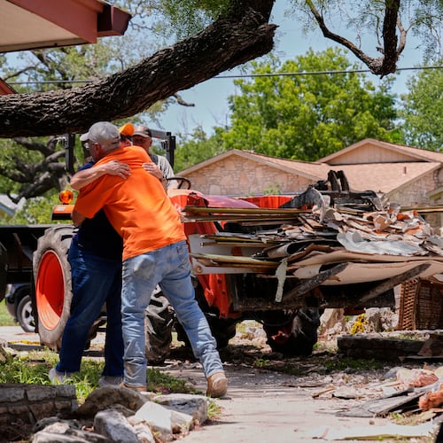 FILE - Homeowner Daniel Olivas hugs Lorrie McMillan, a chaplain with Texans on Mission Disaster Relief, as he clears debris from his home, which was heavily damaged from flash floods along the Guadalupe River in Kerrville, Texas, July 10, 2025. (AP Photo/Gerald Herbert, File)