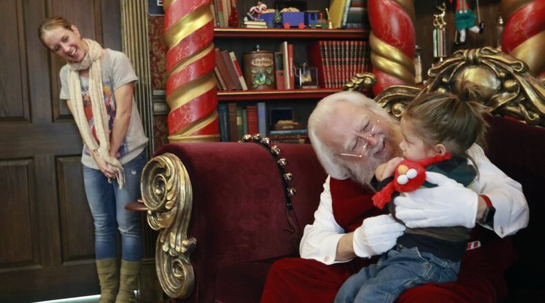 Debbie McGaw watches as her son, Noah, 2, reluctantly visits with Santa at North Point Mall in Alpharetta. Consumers are increasingly buying Christmas gifts online, but Santa visits help draw parents of young kids to malls across the nation. BOB ANDRES /BANDRES@AJC.COM