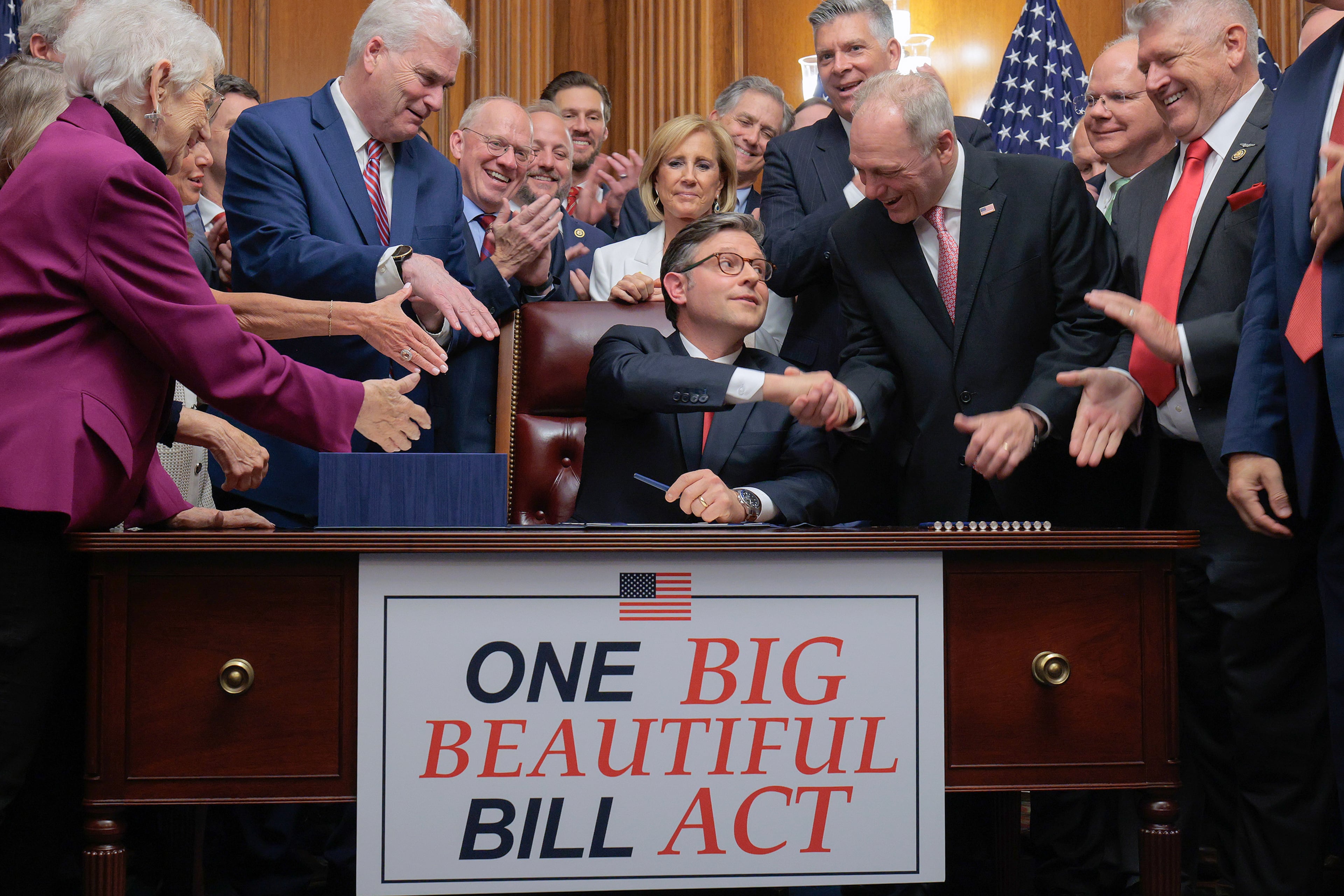 Speaker of the House Mike Johnson (R-LA) (center) is congratulated by his fellow Republicans after signing the "one big, beautiful bill" act during an enrollment ceremony in the Rayburn Room at the U.S. Capitol on July 3, 2025 in Washington. (Chip Somodevilla/Getty Images/TNS)