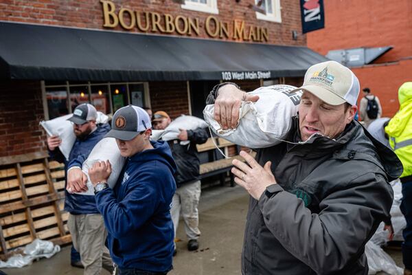 City workers and volunteers stack sandbags in preparation of rising floodwaters on Sunday, April 6, 2025, in Frankfort, Ky. (AP Photo/Jon Cherry)