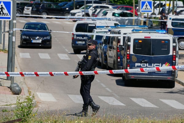 Police officers cordon off the area after an adviser to former Ukrainian president Viktor Yanukovych was shot, outside a school in Madrid, Spain, Wednesday, May 21, 2025. (AP Photo/Paul White)