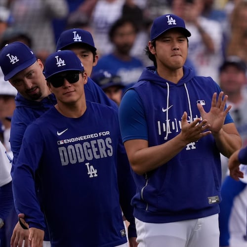 Los Angeles Dodgers' Mookie Betts, right, is congratulated by Shohei Ohtani, center, and Yoshinobu Yamamoto after the Dodgers defeated the San Francisco Giants in a baseball game Sunday, Sept. 20, 2026, in Los Angeles. (AP Photo/Mark J. Terrill)