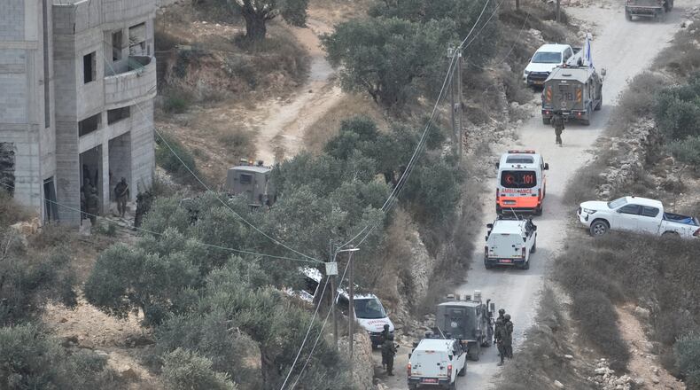 Israeli soldiers secure a building under construction as ambulances evacuate injured Palestinians following an attack by Israeli settlers in the occupied West Bank village of Qusra, Saturday, Aug. 29, 2026. (AP Photo/Majdi Mohammed)