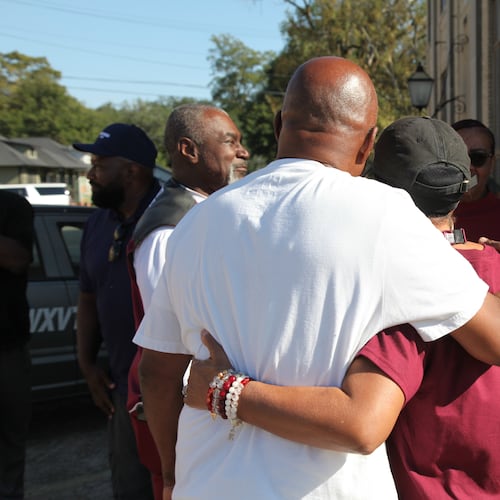 Friends and family of victims of a homecoming shooting embrace in downtown Leland, Miss., Saturday, Oct. 11, 2025. (AP Photo/Katie Adkins)