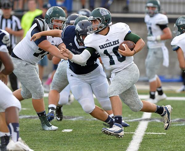 AUGUST 22, 2014 POWDER SPRINGS Walter H. Cantrell Stadium Friday, August 22, 2014. KENT D. JOHNSON / KDJOHNSON@AJC.COM Creekview quarterback Kyle Wilkie runs on the keeper during the first half in the initial game of the 2014 Corky Kell Classic between the Creekview Grizzlies and the North Paulding Wolfpack at McEachern High School. (Kent D. Johnson / AJC)