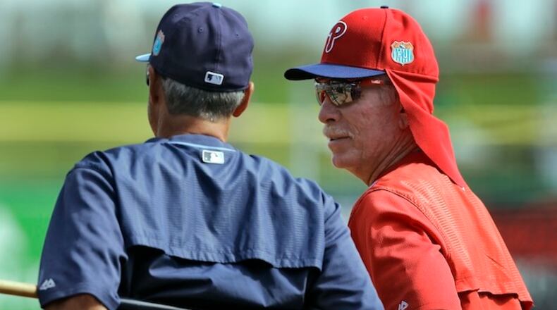 FILE - In this March 17, 2016, file photo, Philadelphia Phillies instructor Mike Schmidt, right, talks to Tampa Bay Rays bench coach Tom Foley before a spring training baseball game in Clearwater, Fla. "The players used to settle issues themselves. Cross the line and someone had to pay, nearly always the players got it right and settled it themselves. Umpires are now the baseball police, which has made the game safer but also softer, " says Schmidt (AP Photo/Chris O'Meara, File)