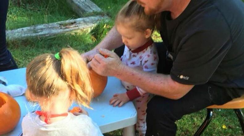 Aurora Crider, left, and her twin sister, Rosaline, with their father, Corey Simmons. The toddlers in Washington state managed to get out of their booster seats and crawl up to a roadway after a car accident that killed their father.