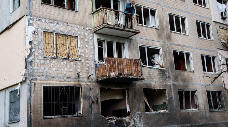 A man stands at a balcony of an apartment building damaged after a Russian drone strike in Kyiv, Ukraine, on Tuesday, Sept. 22, 2026. (AP Photo/Evgeniy Maloletka)