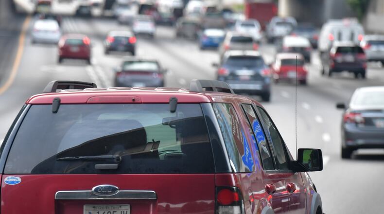 A driver apparently uses a phone while driving in downtown Atlanta on Thursday, June 21, 2018. The Hands-Free Georgia Act, which went into effect July 1, prohibits motorists from holding their phones or other electronic devices while driving. HYOSUB SHIN / HSHIN@AJC.COM