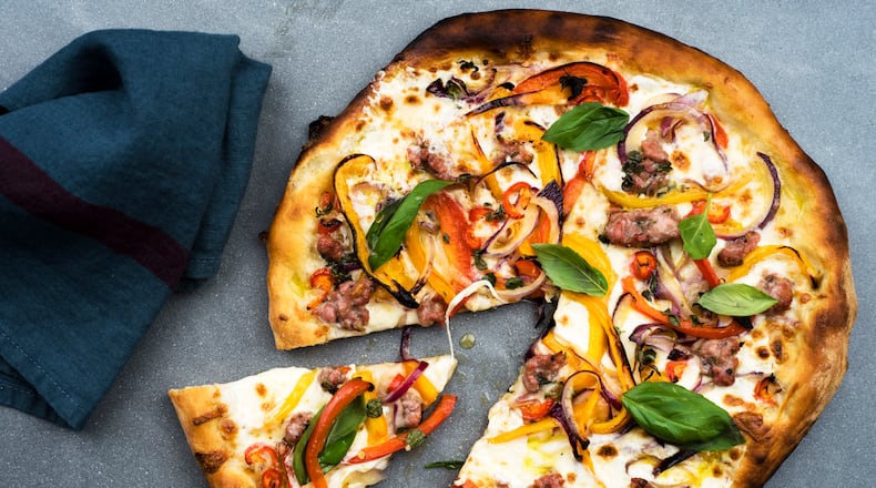 A pizza with mozzarella, peppers, garlic, basil, onions, marjoram and fennel sausage in New York, Sept. 1, 2015. A light colorful pepper strewn pizza is a great way to get a bit of summer's flavor during the winter months