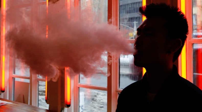 A customer exhales vapor from an e-cigarette. (AP Photo/Frank Franklin II)