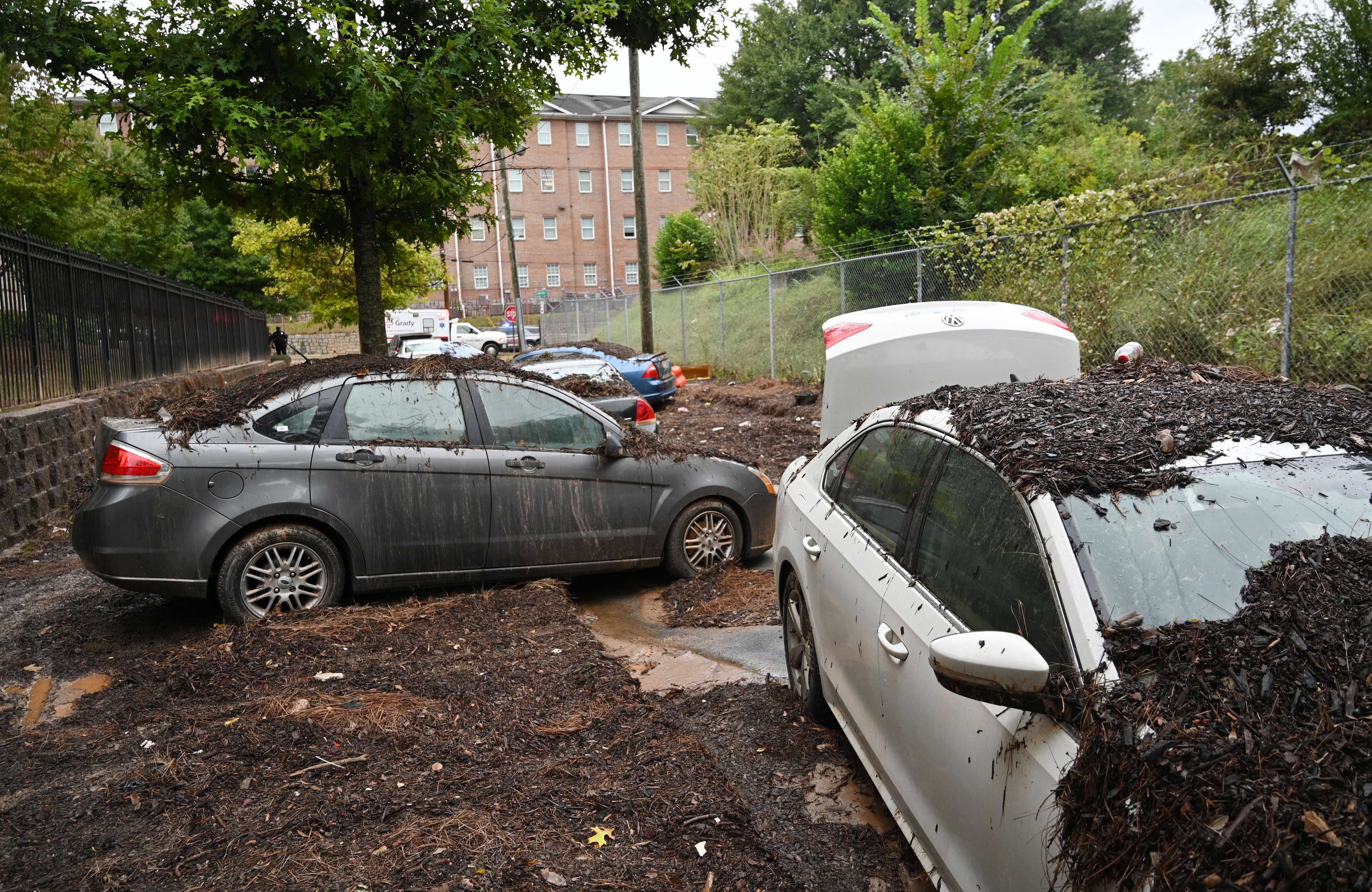 Damaged cars are stuck in the mud after storms dropped nearly 4 inches of rain near Clark Atlanta University campus in 2023. (Hyosub Shin/AJC)