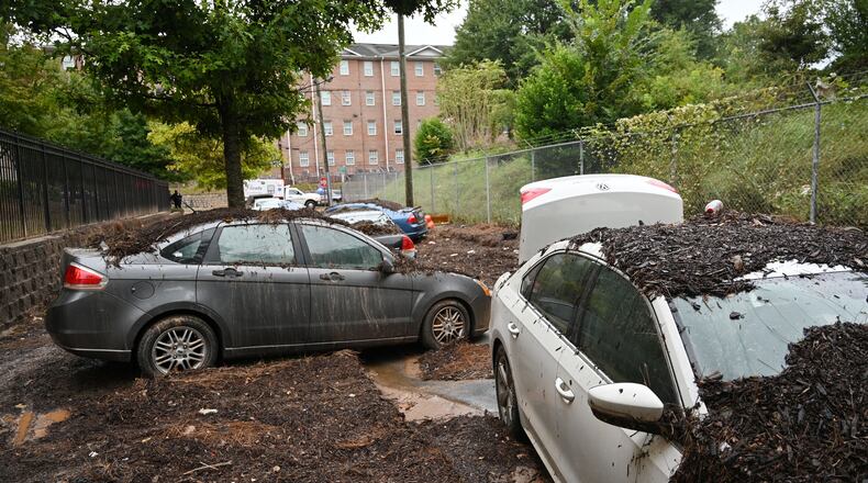 Damaged cars are stuck in the mud after storms dropped nearly four inches of rain near Clark Atlanta University campus, Friday, September 15, 2023, in Atlanta. Metro Atlanta is turning to cleanup efforts Friday after storms dropped nearly four inches of rain over downtown and caused major flash flooding that sent cars floating through streets the day before. (Hyosub Shin / Hyosub.Shin@ajc.com)